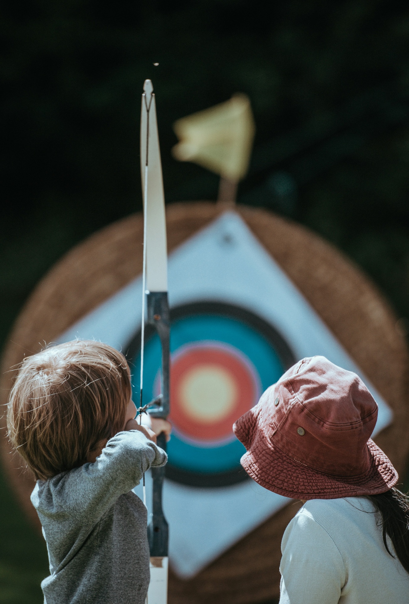 Kids learning archery outdoors